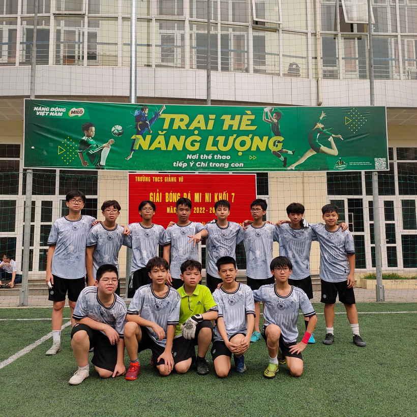 A group of people posing for a photo in front of a signDescription automatically generated