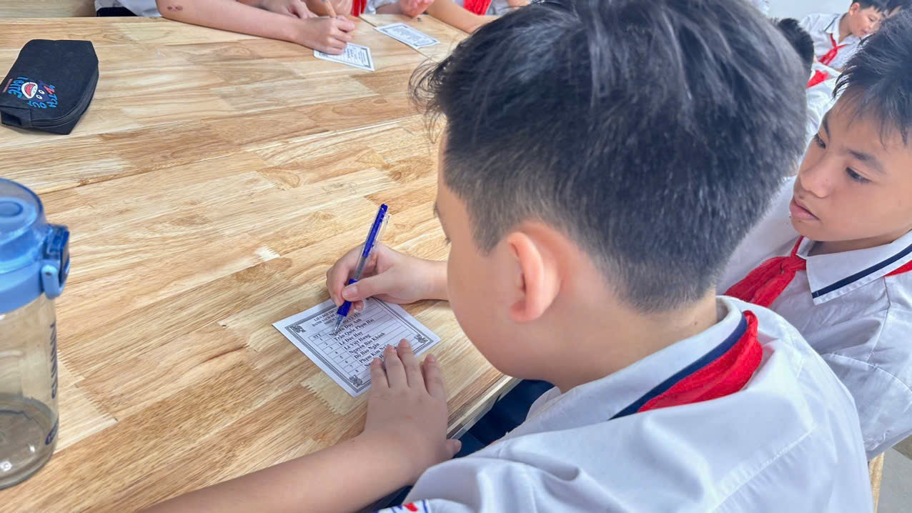 A child sitting at a table writing on paperDescription automatically generated