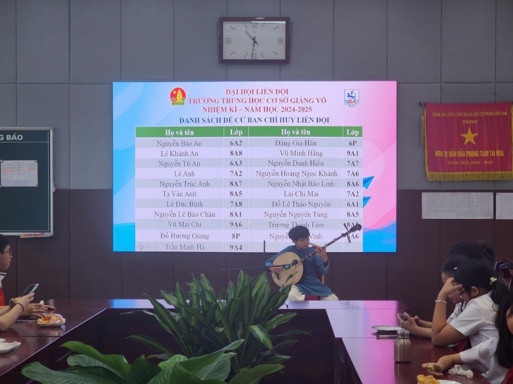 A group of people sitting at a table playing a musical instrumentDescription automatically generated