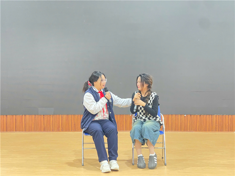 Two women sitting in chairs talking to each otherDescription automatically generated