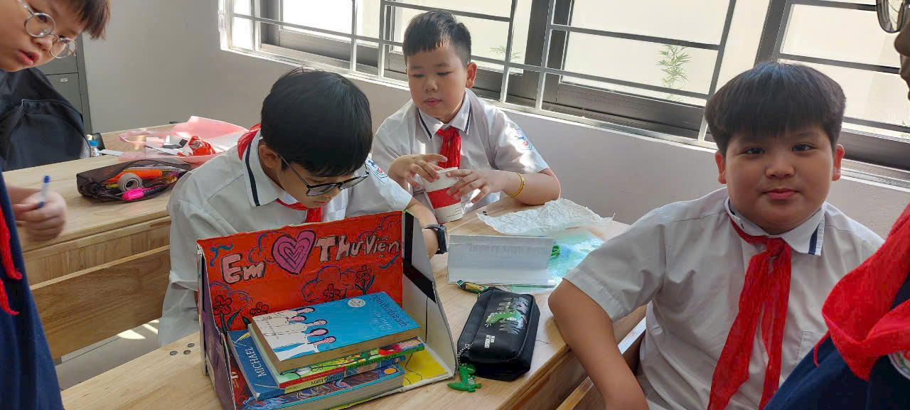 A group of boys sitting at a table with booksAI-generated content may be incorrect.