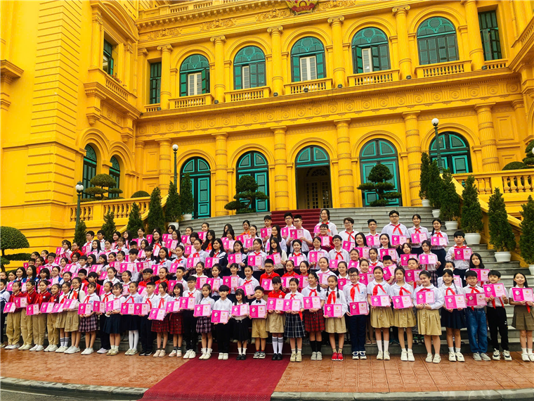 A group of children in front of a yellow buildingAI-generated content may be incorrect.