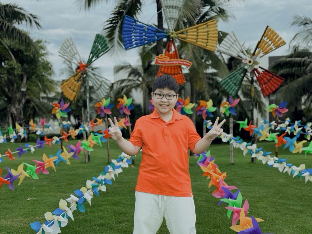 A child standing in front of colorful pinwheelsDescription automatically generated