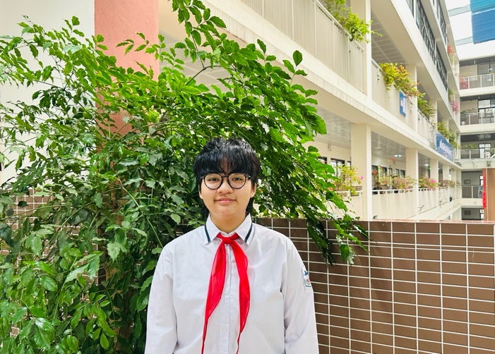 A person in a white shirt and red scarfDescription automatically generated